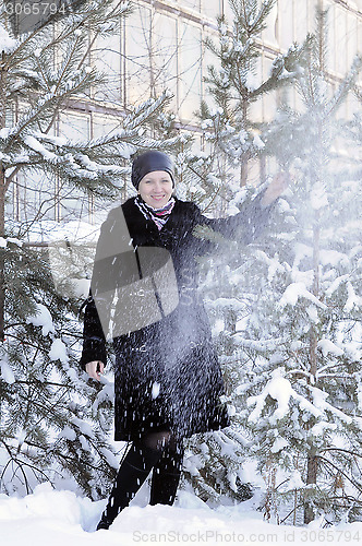 Image of The cheerful woman in a black fur coat costs at snow-covered pin