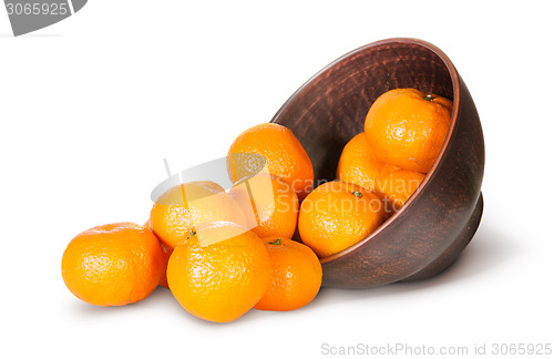 Image of Tangerines Spill Out Of Clay Bowl