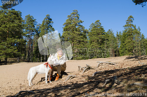 Image of The woman with a white dog in a wood