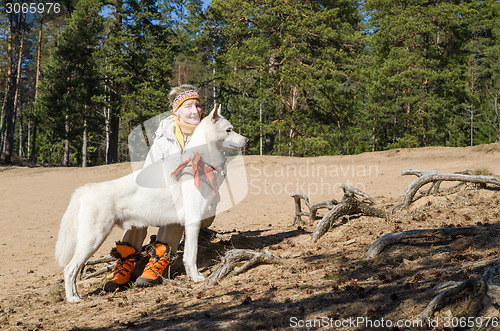 Image of The woman with a white dog in a wood