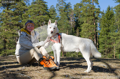 Image of The woman with a white dog in a wood