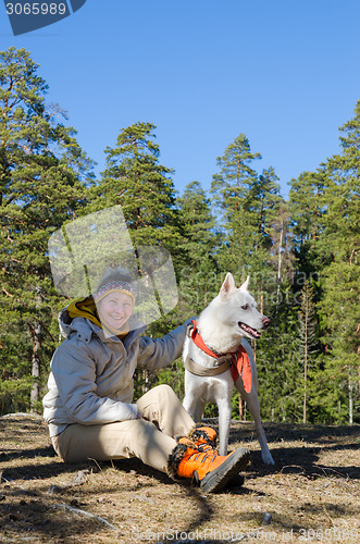 Image of The woman with a white dog in a wood