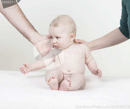 Image of baby is supported by arms