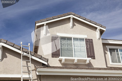 Image of Ladder Leaning Up Against A Freshly Painted Home