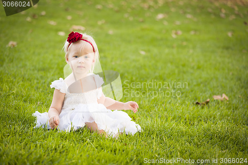 Image of Adorable Little Girl Wearing White Dress In A Grass Field