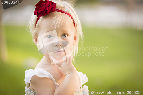 Image of Adorable Little Girl Wearing White Dress In A Grass Field