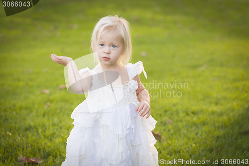 Image of Adorable Little Girl Wearing White Dress In A Grass Field