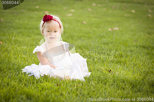 Image of Adorable Little Girl Wearing White Dress In A Grass Field