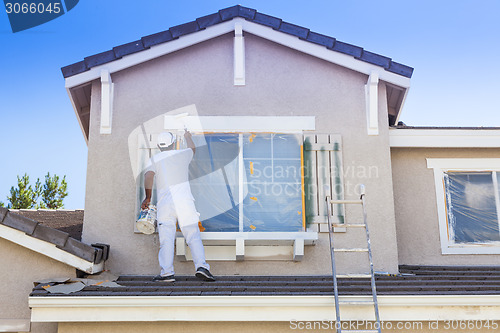 Image of House Painter Painting the Trim And Shutters of Home