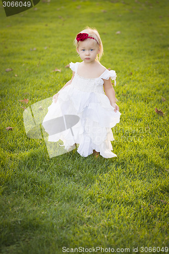 Image of Adorable Little Girl Wearing White Dress In A Grass Field