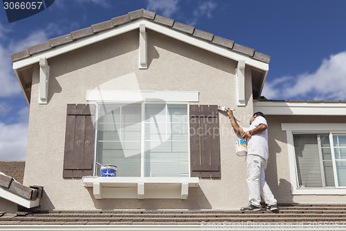 Image of House Painter Painting the Trim And Shutters of Home