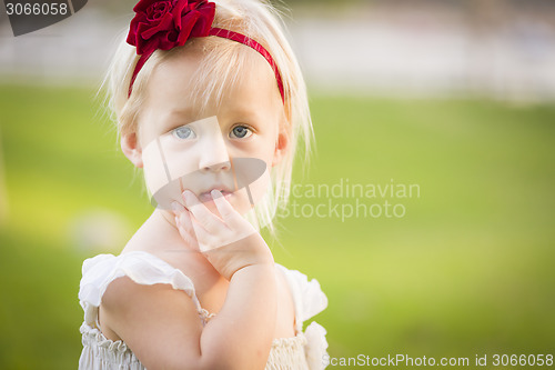 Image of Adorable Little Girl Wearing White Dress In A Grass Field