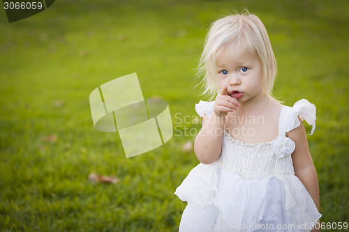 Image of Adorable Little Girl Wearing White Dress In A Grass Field