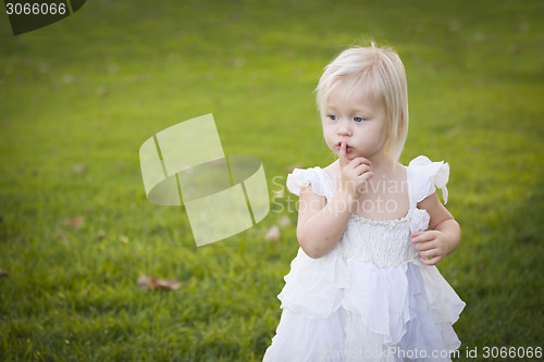 Image of Adorable Little Girl Wearing White Dress In A Grass Field