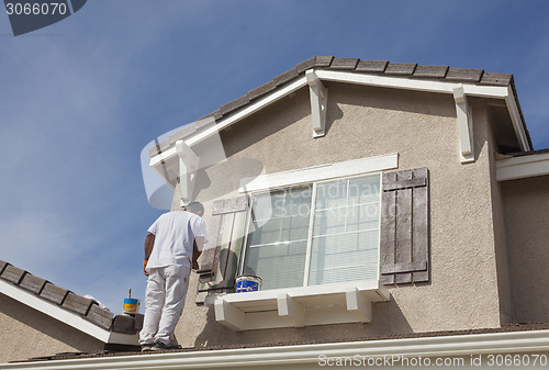 Image of House Painter Painting the Trim And Shutters of Home