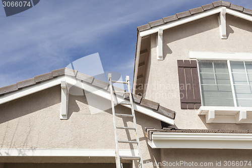 Image of Ladder Leaning Up Against A Freshly Painted Home