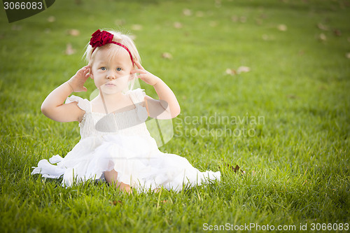 Image of Adorable Little Girl Wearing White Dress In A Grass Field