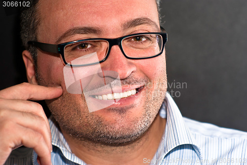 Image of Smiling bearded caucasian man wearing eyeglasses striped shirt