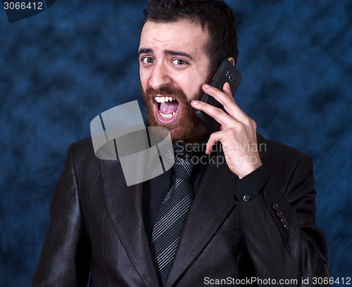 Image of Man in business suit shouting into his mobile phone