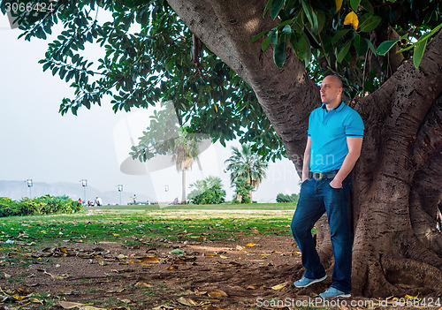 Image of Man poses outside in the park