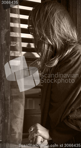 Image of young woman looks out the window