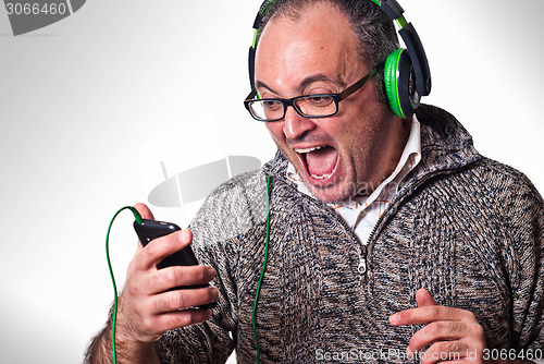 Image of Man listen music on headphones and scream aloud