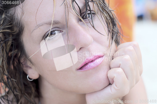Image of Beautiful wistful woman looking directly at camera
