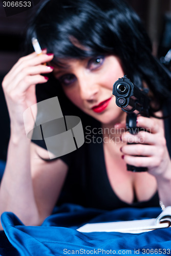 Image of Beautiful brunette girl with cigarette and gun