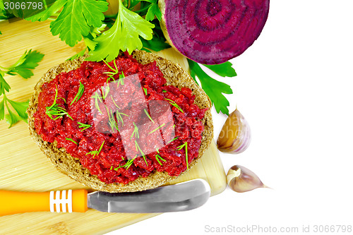 Image of Sandwich with beet caviar and knife on board