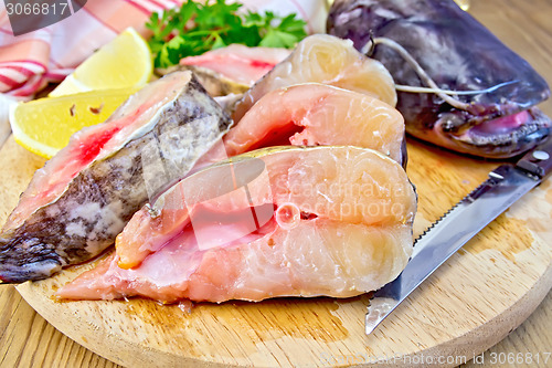 Image of Catfish raw with knife on board