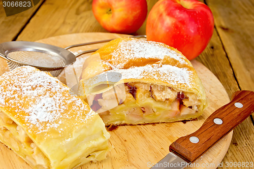 Image of Strudel apple with strainer and knife on board