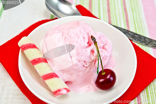 Image of Ice cream cherry on red paper napkin with spoon