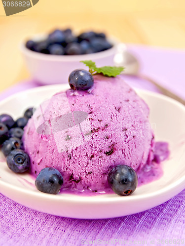 Image of Ice cream blueberry in bowl on purple napkin