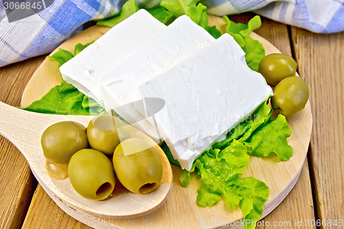 Image of Feta with olives and lettuce on board and spoon
