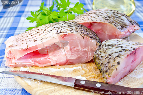 Image of Bream raw with parsley on fabric