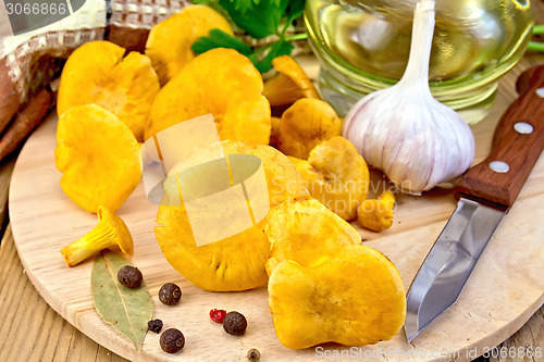 Image of Chanterelles with spices and oil on board