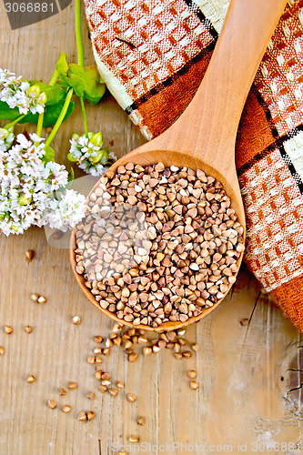 Image of Buckwheat in spoon on board with flower and doily