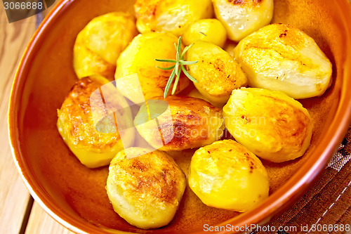 Image of Potatoes fried in ceramic pan on board