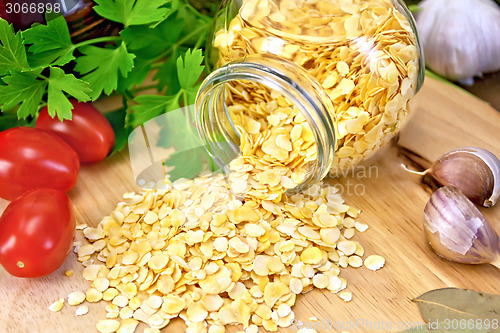 Image of Pea flakes in jar with garlic on board