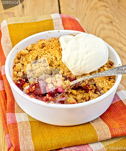 Image of Crumble cherry in bowl with ice cream on board