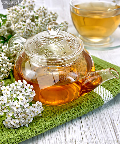 Image of Tea with yarrow in glass teapot on board