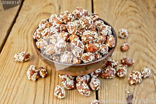 Image of Peanuts in caramel with sesame on wooden board