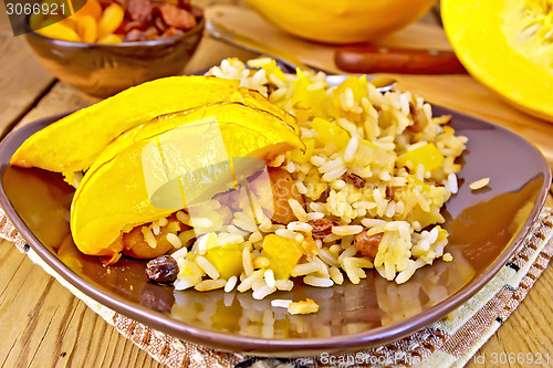 Image of Pilaf fruit with pumpkin in brown plate on board