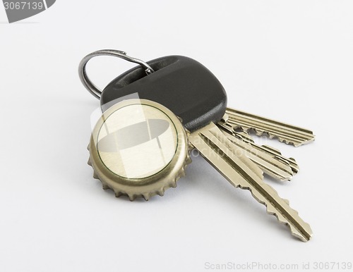 Image of car key and bottle cap in close up