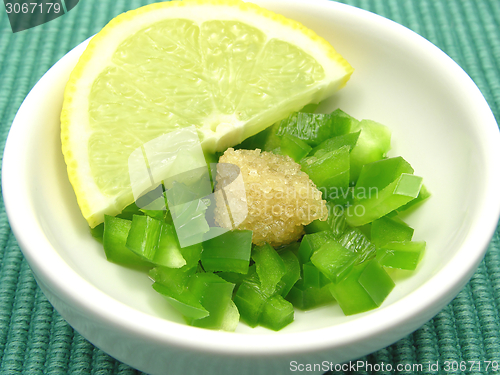 Image of Dices of green  pepper with sugar and lemon in a little bowl of chinaware