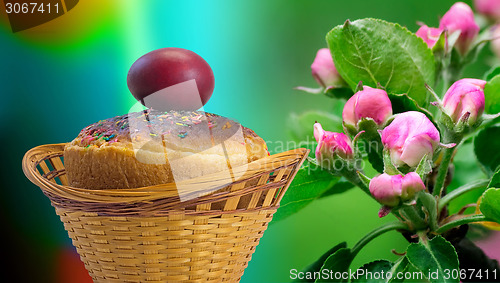 Image of Easter cakes and red Easter egg beside a blossoming Apple tree.