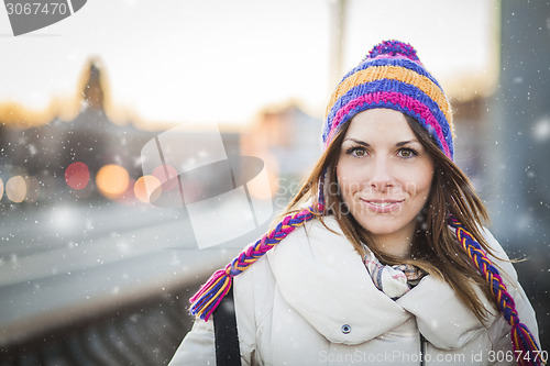 Image of Positive girl with colorfull hat in winter city