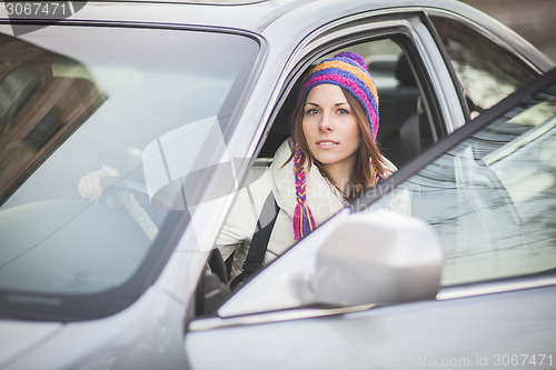 Image of Young woman in a rental car