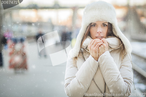 Image of Youn woman on a train station in winter