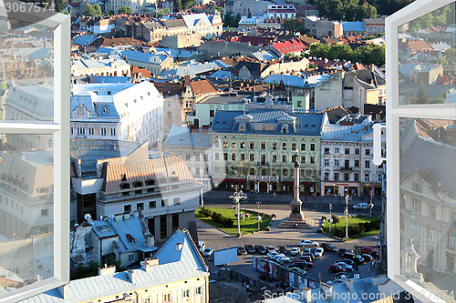 Image of opened window to the roofs of city